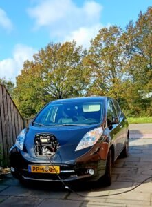 Groene dak voorbereiden op de winter. Zwarte Nissan Leaf aan het laden